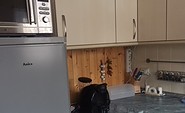 Küche mit Mikrowelle und Kühlschrank