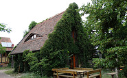 Das Lehm-Ferienhaus in Schönhagen mit Sitzecke draußen. Foto: Gabriele Sußdorf