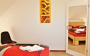Schlafzimmer mit Doppelbett und Blick auf einen Ganzkörperspiegel, Foto: Ulrike Haselbauer, Lizenz: Tourismusverband LSL e.V.