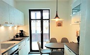 Küche mit Sitzmöglichkeit und Zugang zum Balkon, Foto: Laura Schmidt, Lizenz: TV Lausitzer Seenland e.V.