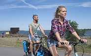 Radfahrer fahren am Schwimmenden Haus am Partwitzer See vorbei, Foto: Nada Quenzel, Lizenz: Tourismusverband Lausitzer Seenland e.V.