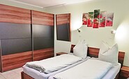 1.Schlafzimmer mit Doppelbett und Sideboard mit TV, Foto: Laura Schmidt, Lizenz: Tourismusverband Lausitzer Seenland e.V.