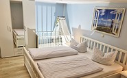 Schlafzimmer mit Doppelbett und Kinderbettchen, Foto: Sabine und Enrico Ende, Lizenz: Ferienhaus Boxberg
