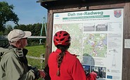 Radler vor Infotafel zum DahmeRadweg, Foto: Dana Klaus, Lizenz:  Tourismusverband Dahme-Seenland e.V.