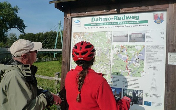 Radler vor Infotafel zum DahmeRadweg, Foto: Dana Klaus, Lizenz:  Tourismusverband Dahme-Seenland e.V.