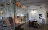 Ein Schreibtisch mit Vitrine zu sehen im Kurt Tucholsky Literaturmuseum