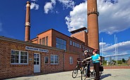 Radler am Kraftwerk Plessa, Foto: Tourismusverband Elbe-Elster-Land e.V./Lars Reßler