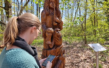 Knobelspaß an der Holzskulptur Gundling, Foto: Sandra Fonarob, Lizenz: Tourismusverband Dahme-Seenland e.V.