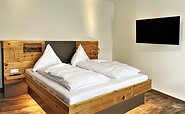 1. Schlafzimmer mit Doppelbett aus Zirbenholz und Flatscreen-TV, Foto: Ulrike Haselbauer, Lizenz: Tourismusverband Lausitzer Seenland e.V.