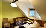 Schlafzimmer Nr.1 mit Doppelbett und Kinderbettchen, Foto: Ulrike Haselbauer