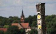 Wanderwegweiser vor der Kirche Wiesenburg, Foto: Bansen-Wittig