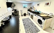 Küche mit 2 Waschmaschinen, Trockner, Spülmaschine, Wasserkocher, Filter-Kaffeemaschine, Espressomaschine, Toaster, Mikrowelle, Ofen, Foto: Hüller