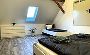 FeWo Reichwalde: Blick vom Doppelbett auf weiteres Einzelbett im Schlafzimmer, Foto: Ulrike Haselbauer, Lizenz: Tourismusverband Lausitzer Seenland e.V.