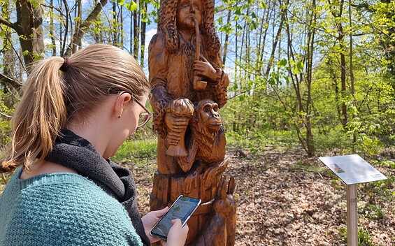Knobelspaß an der Holzskulptur Gundling, Foto: Sandra Fonarob, Lizenz: Tourismusverband Dahme-Seenland e.V.