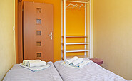 Schlafzimmer 2 mit Doppelbett und Kleiderregal, Foto: Manja Motylski, Lizenz: GUWO
