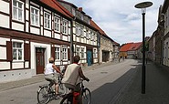 Radfahrer durch die Lenzener Innenstadt entlang alter Fachwerkhaeuser, Foto: Henry Mundt