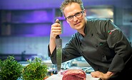 Der Küchenchef posiert mit einem Messer in der Hotelküche, Foto: Stefan Effner