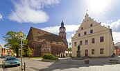 Marktplatz mit Backsteinkirche, hellem Giebelhaus, Statue, Kopfsteinpflaster und blauem Himmel mit Wolken., Foto: Andreas Franke, Lizenz: Andreas Franke