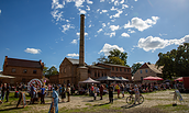 Menschen versammeln sich bei sonnigem Himmel vor historischen Backsteinbauten mit Schornstein auf einem Erntedankfest, Foto: Erste Bernauer Braugenossenschaft e. G., Lizenz: Erste Bernauer Braugenossenschaft e. G.