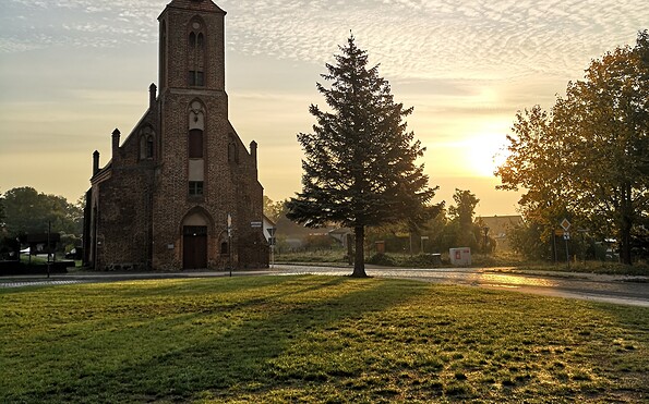 Eine Kapelle im Sonnenuntergang mit einer Wiese davor, Foto: Merith Sommer, Lizenz: TMU GmbH