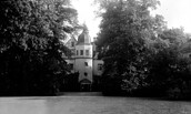 Nordansicht von Schloss Königs Wusterhausen durch eine Lücke zwischen zwei Bäumen, Schwarz-Weiß-Foto von 1938, Foto: Oberhofmarschallamt/ 	Verwaltung der Staatlichen Schlösser und Gärten (1927-1945), Lizenz: SPSG