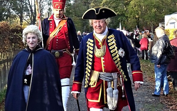 Mike Sprenger als König Friedrich Wilhelm I. und Manuela Sprenger als Königin Sophie Dorothea im Hintergrund ein „Langer Kerl“, Foto: Förderverein Jagdschloss Stern-Parforceheide e.V., Lizenz: Förderverein Jagdschloss Stern-Parforceheide e.V.