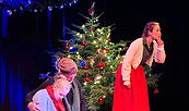 Bühnenszene Stück Weihnachtsgans Auguste Temnitzkirche Netzeband Weihnachtsbaum im Hintergrund und drei Schauspieler, Foto: Veronika Zohova, Lizenz: Netzeband Kultur