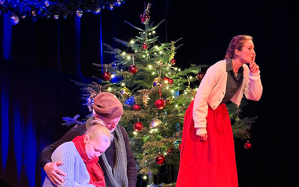 Bühnenszene Stück Weihnachtsgans Auguste Temnitzkirche Netzeband Weihnachtsbaum im Hintergrund und drei Schauspieler, Foto: Veronika Zohova, Lizenz: Netzeband Kultur