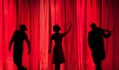Drei Silhouetten von Schauspielern vor einem roten Theatervorhang, Foto: Kyle Head | Unsplash