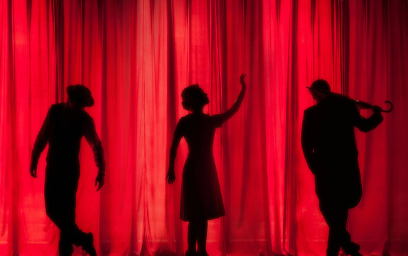 Drei Silhouetten von Schauspielern vor einem roten Theatervorhang, Foto: Kyle Head | Unsplash