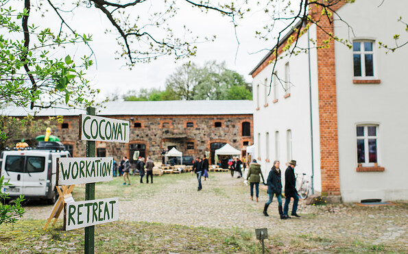 Menschem auf dem Hof mit Schild vorm Coconat, Foto: Tilmann Vogler, Lizenz: Tilmann Vogler