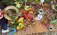 Draufsicht auf einen Tisch, an dem Hände aus bunten Herbstblättern, Beeren und Zweigen Kränze binden., Foto: Nicole Riekeles , Lizenz: Nicole Riekeles