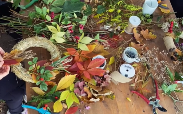 Draufsicht auf einen Tisch, an dem Hände aus bunten Herbstblättern, Beeren und Zweigen Kränze binden., Foto: Nicole Riekeles , Lizenz: Nicole Riekeles