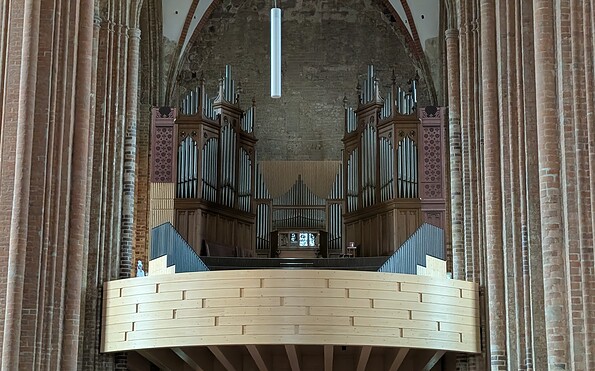 Innenraum einer Backsteinkirche mit hohen Säulen, Rundbögen, Orgelpfeifen und hölzerner Empore., Foto: Merith Sommer, Lizenz: Merith Sommer